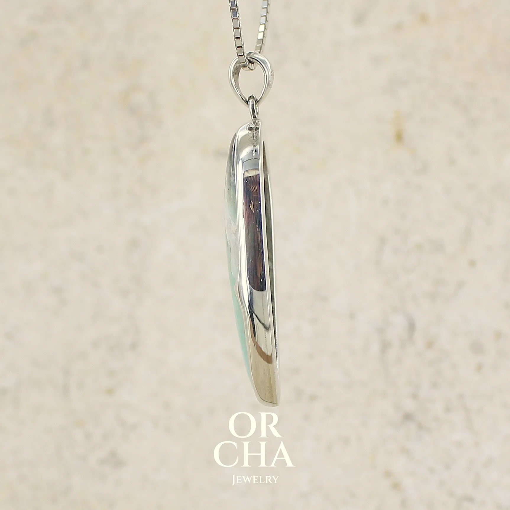 profil d'un pendentif goutte en argent massif, serti d'un cabochon de calcédoine bleue verte  Pierre paysage de qualité translucide et opaque comportant des inclusions. Bijoux unique par Orcha jewelry