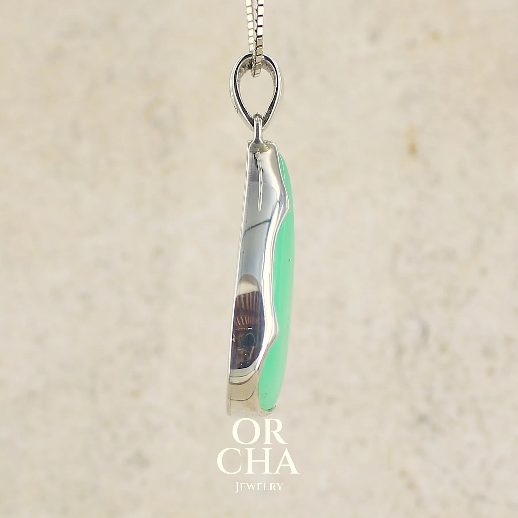profil d'un pendentif pour femme en argent massif, sertie d'un cabochon de chrysoprase de couleur vert pomme. Cabochon de qualité translucide taillée en  forme de goutte. Bijoux unique par Orcha jewelry