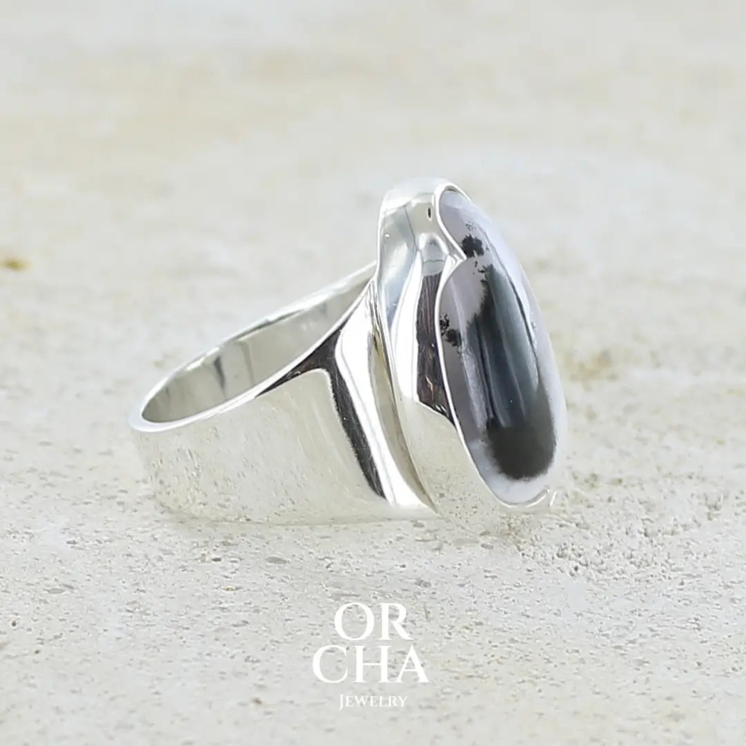 sertissage d'une bague pour femme en argent massif sertie d'un cabochon d'agate dendritique de couleur blanc pur et noir. Pierre opaque translucide à inclusions paysages de dendrites de manganèse noires contrastées. Bijou unique réalisée en taille 56 par Orchajewelry
