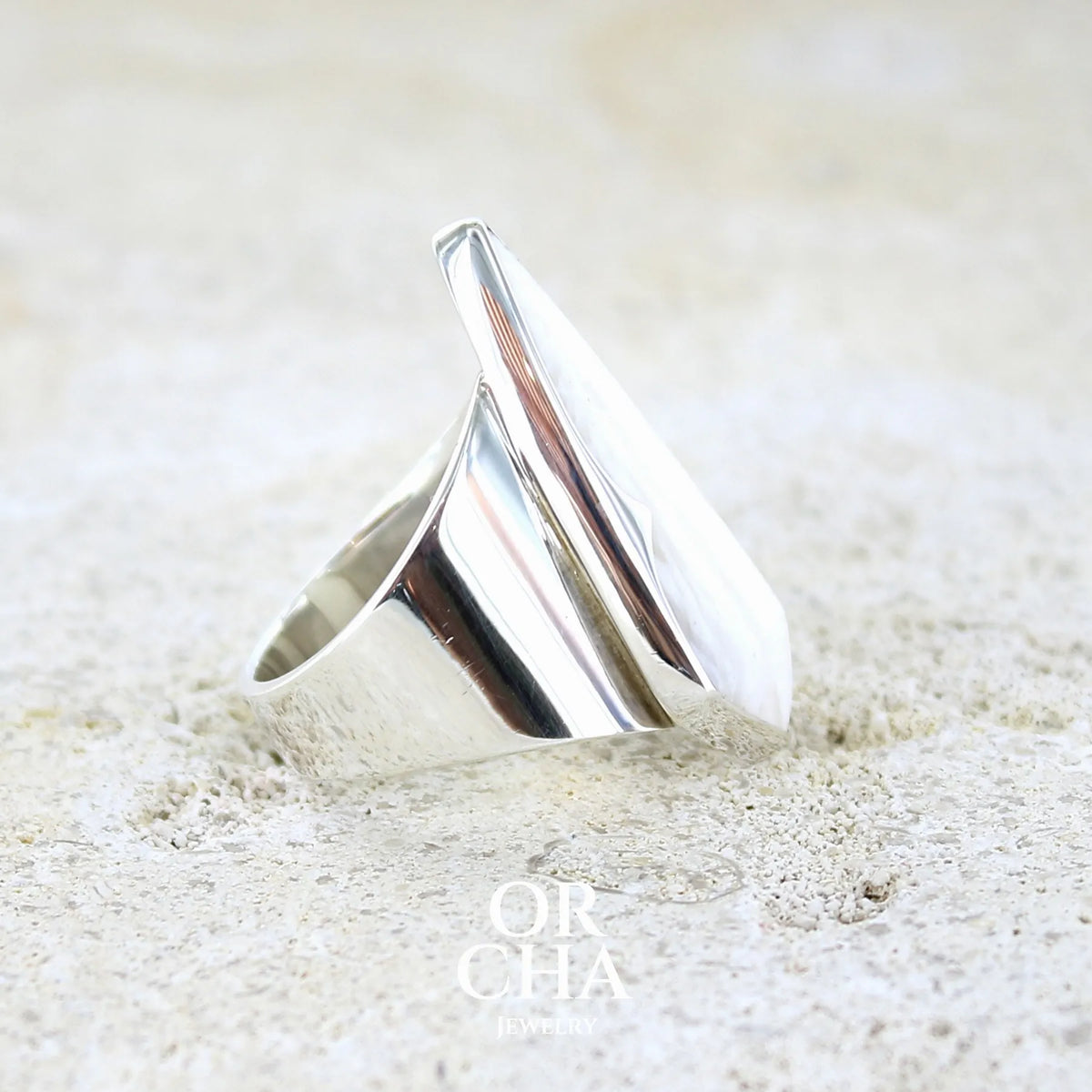 detail du sertissage d'une bague contemporaine pour femme en argent massif sertie d'une scolecite blanche. Pierre naturelle de qualité opaque taillée en forme de losange. Bague unique réalisée en taille 56 par Orcha jewelry